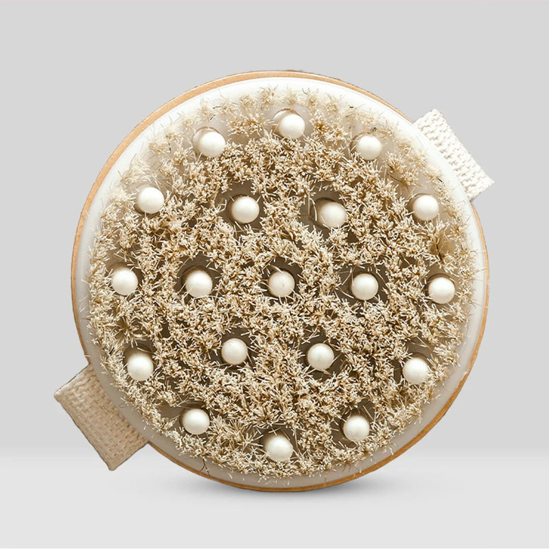 Round brush with bristles and pearl-like beads on a light gray background