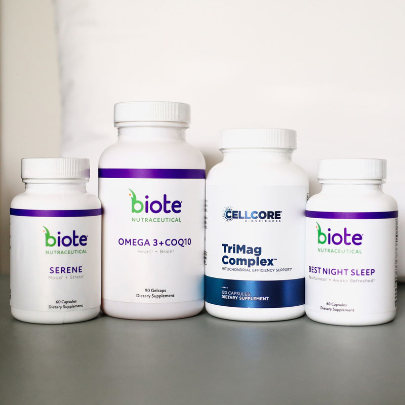 Four white supplement bottles from Biote Nutracetical arranged on a gray surface against a white background. The bottles are labeled Serene, Omega 3 + CQ10, TriMag Complex, and Best Night Sleep.