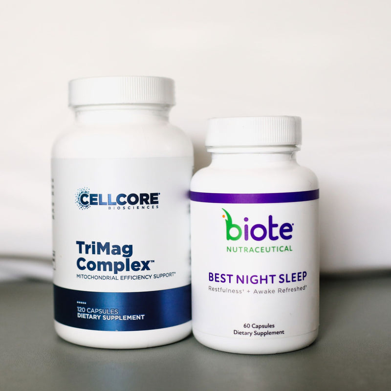 Two white dietary supplement bottles on a gray surface against a white background. The larger bottle on the left is Cellcore HydroSciences TriMag Complex, and the smaller bottle on the right is biote Nutraceutical Best Night Sleep.