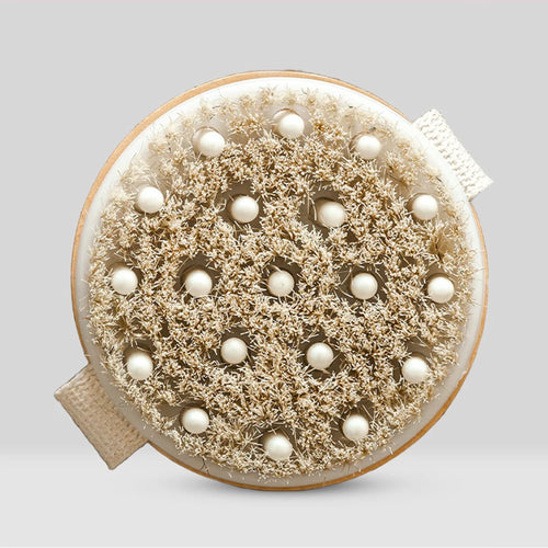 Round brush with bristles and pearl-like beads on a light gray background