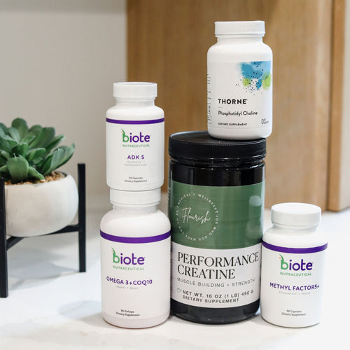 A stack of five dietary supplement bottles and jars from Biote Nutritionals and Thorne, arranged on a white surface with a small potted succulent in the background.