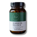 A bottle of Flairish Hormone Balance dietary supplement capsules, featuring an amber glass bottle, a black cap, and a green and white label.