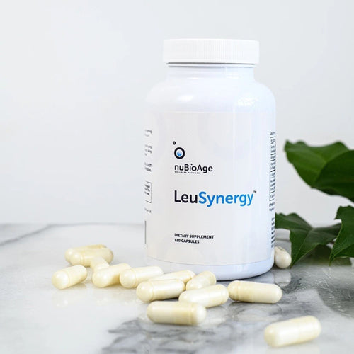 nuBioAge LeuSynergy dietary supplement bottle with capsules on a marble surface