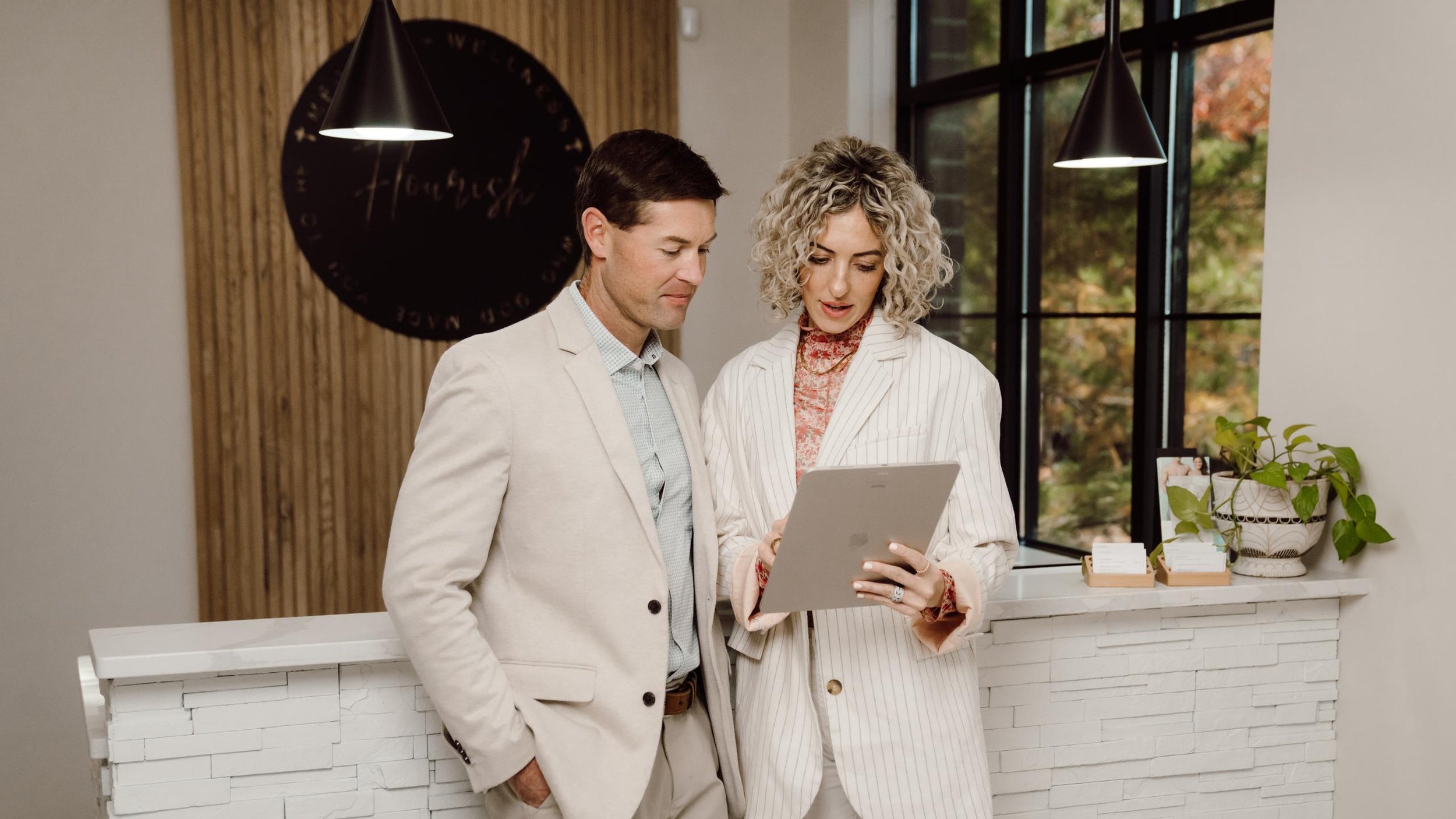 Two people looking at a tablet in a modern interior setting