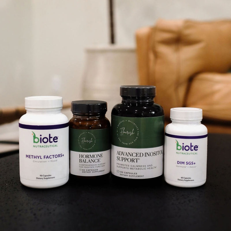 Four biote Nutracutential dietary supplement bottles arranged on a dark tabletop with a blurred indoor background. The bottles include Methyl Factors+, Hormone Balance, Advanced Inostal Support, and Dim SGS+.